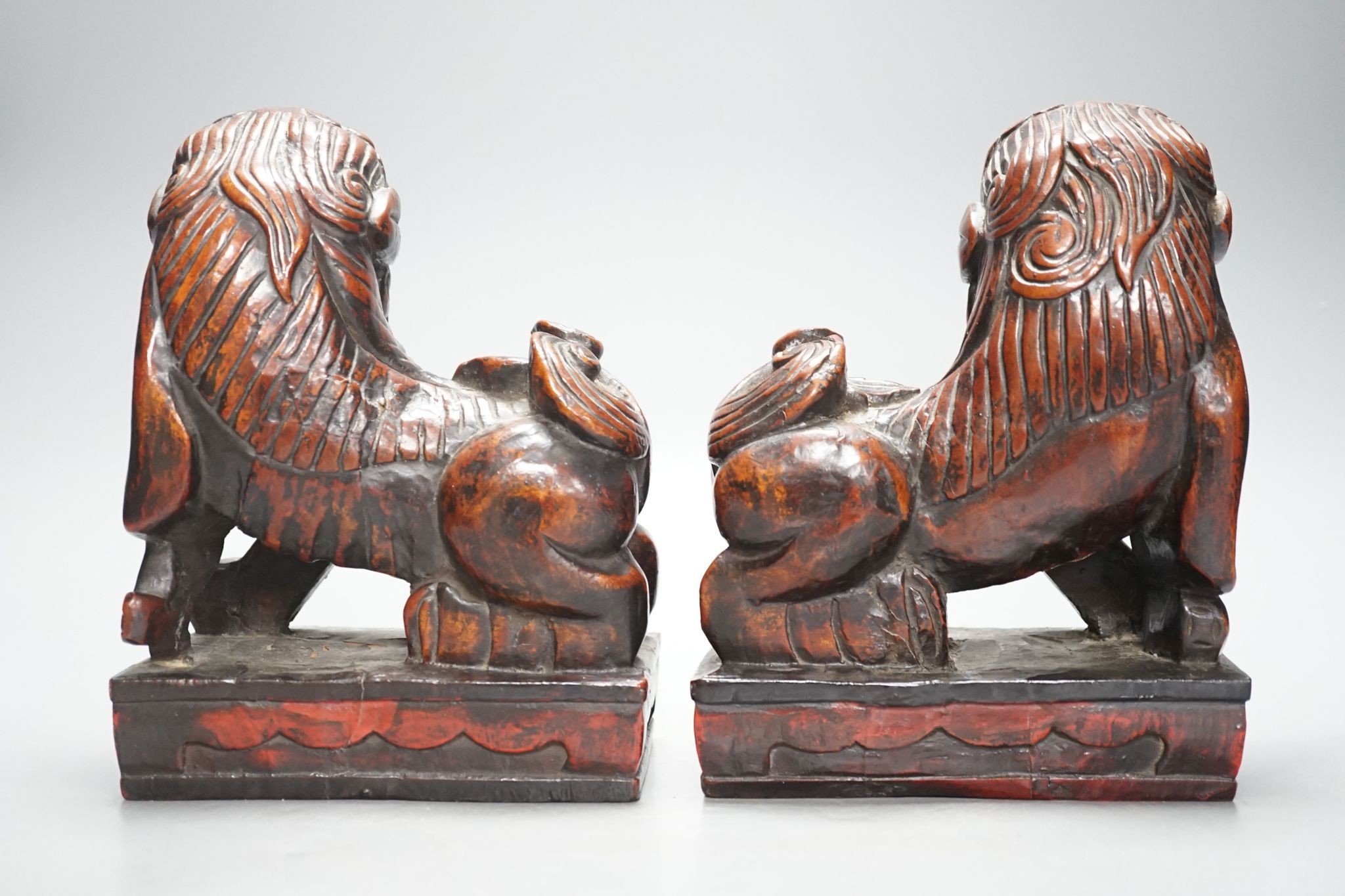 A pair of Japanese carved and red lacquered wood models of temple dogs, Edo period, 21.5 cms high.